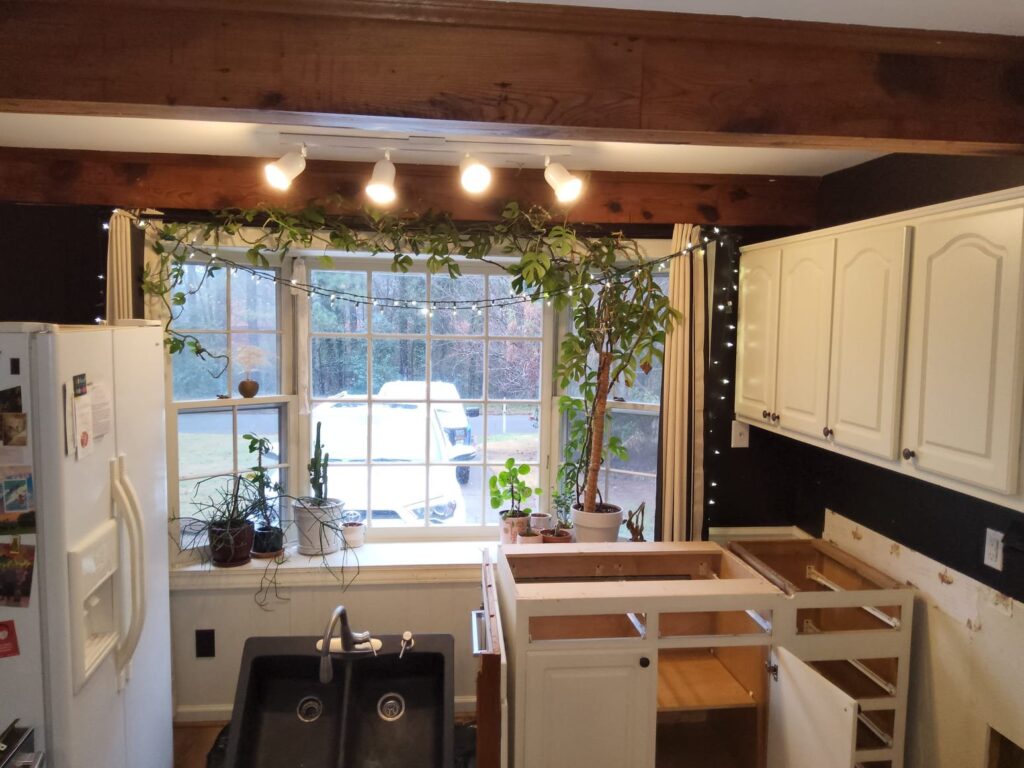 A water damaged kitchen with cabinets out of place and a sink on the floor