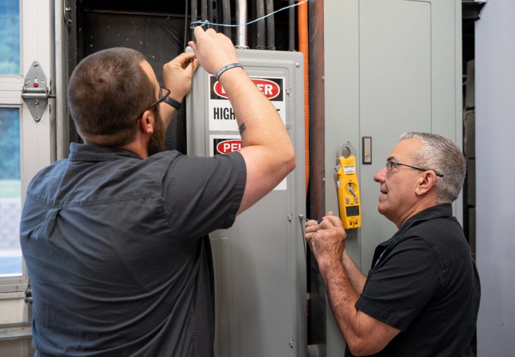 electricians working on a commercial panel box