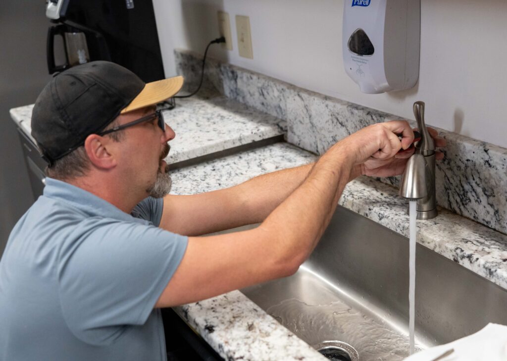 plumber repairing a break room faucet