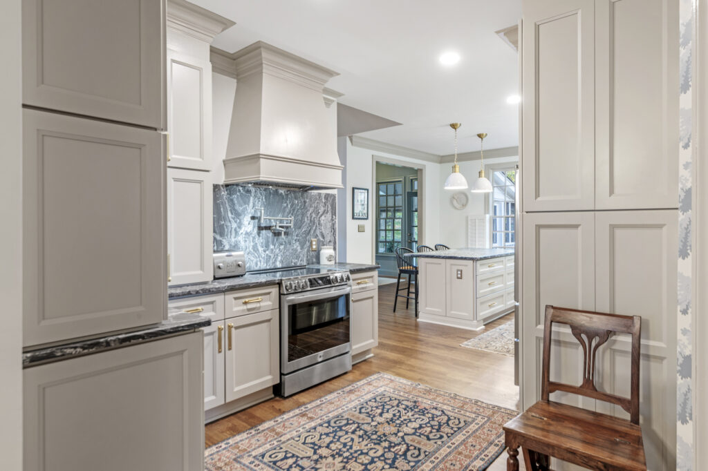 A remodeled kitchen with custom wood range hood