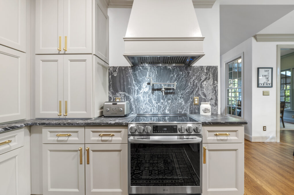 a remodeled kitchen with custom wood range hood and quartz backsplash