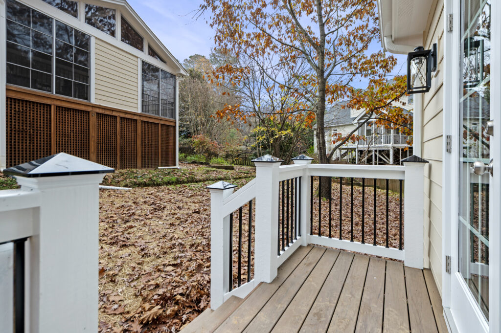 The porch of a detached building that is used as an office with the primary house in the background