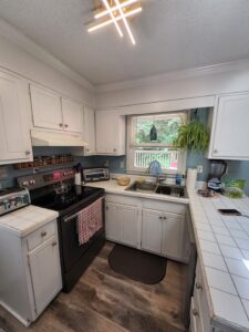 Kitchen showing sink, stove and countertop before remodeling