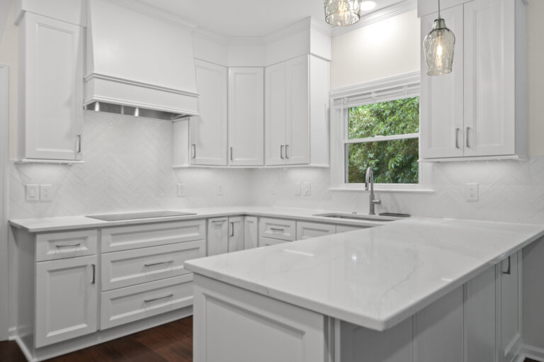 Kitchen remodel showcasing a custom range hood, cabinets and countertop