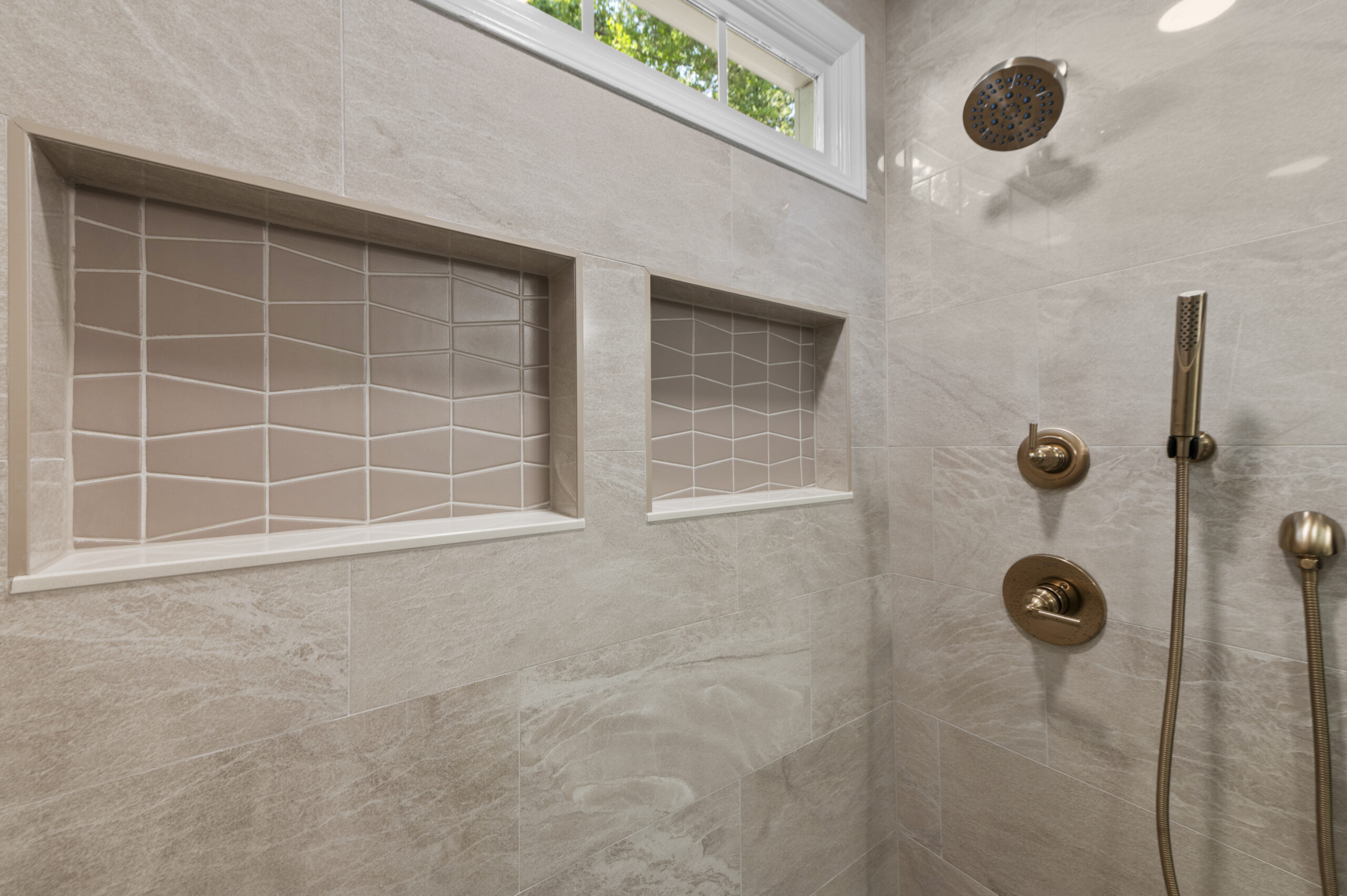 Shhower focusing on shower plumbing fixtures and recessed niches.
